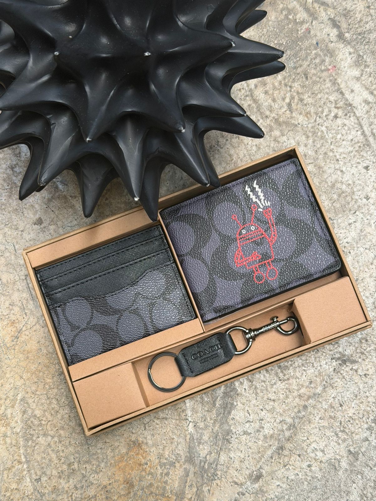 SET CARTERA COACH ESTAMPADO NEGRO ROBOT ROJO