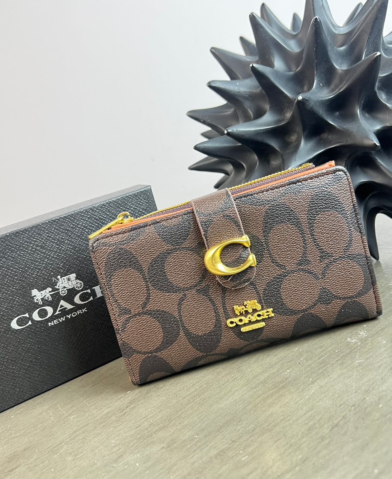 CARTERA COACH BROCHE CAFE ESTAMPADO