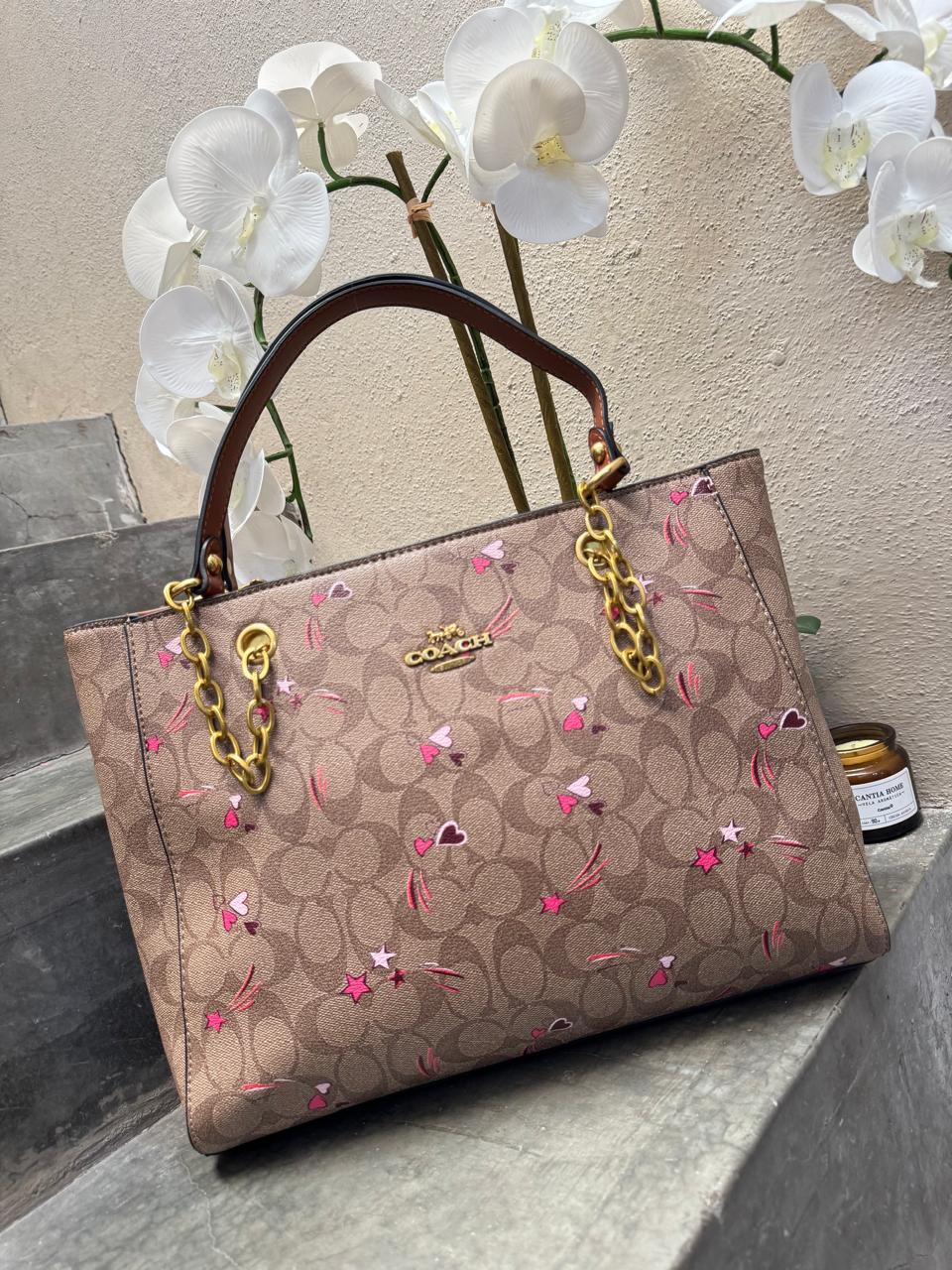 TOTE COACH MEDIANA CON CADENA KHAKI CORAZONES Y ESTRELLAS